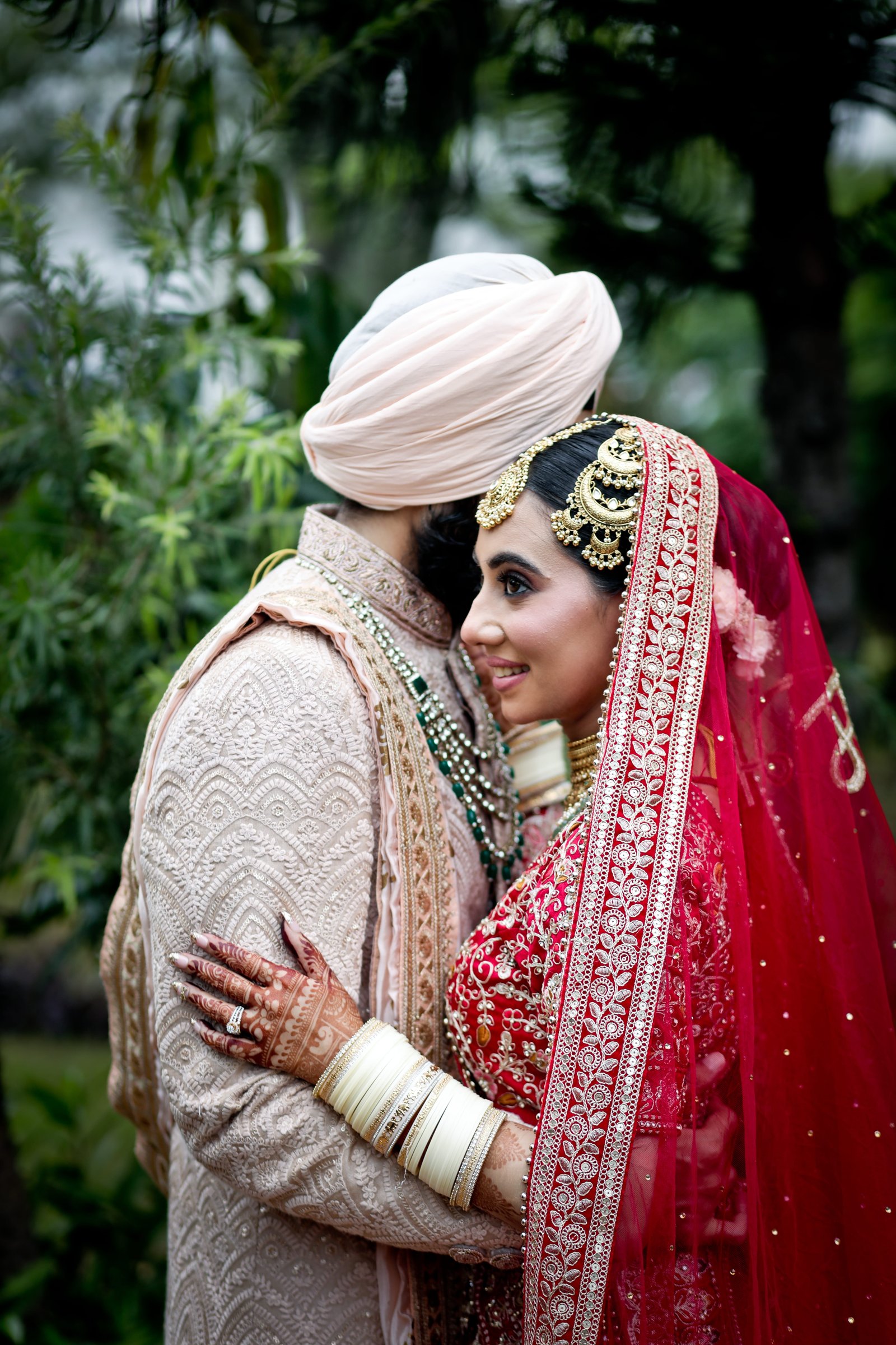 side view of beautiful happy young wedding couple able to kiss in park